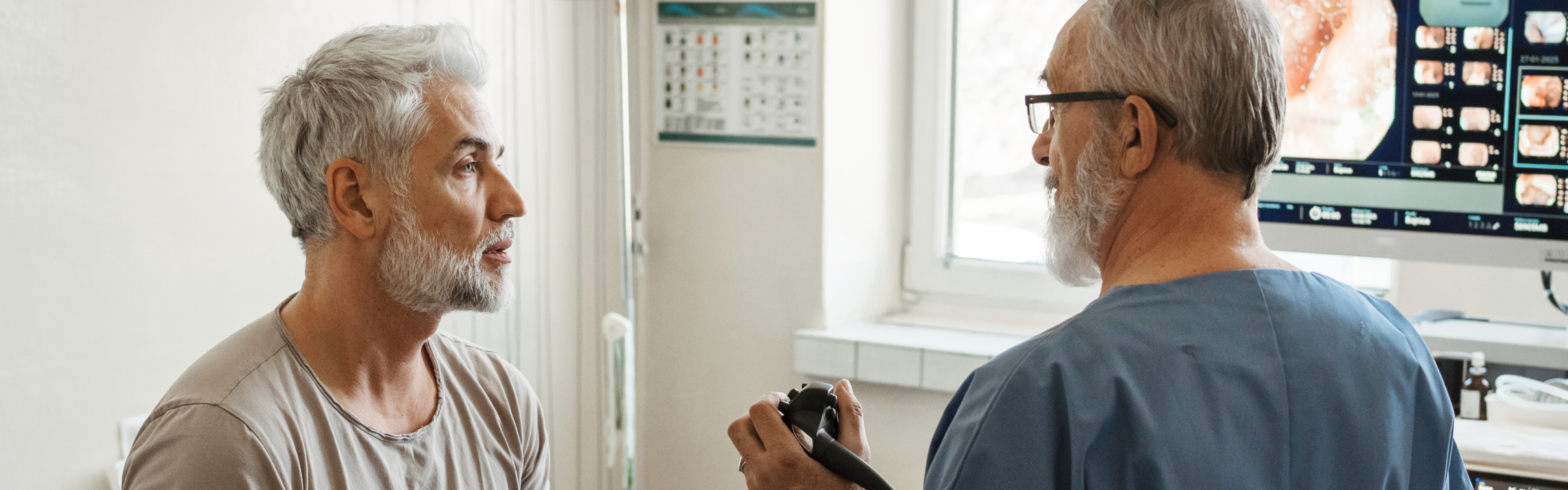 Arzt bespricht Untersuchungsergebnisse mit Patient in der gastroenterologischen Praxis