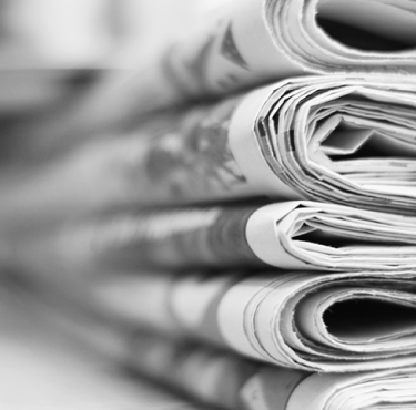 Stapel gefalteter Zeitungen in Schwarzweiß