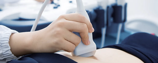 Nahaufnahme einer Ultraschallsonde, im Hintergrund das Ultraschallgerät