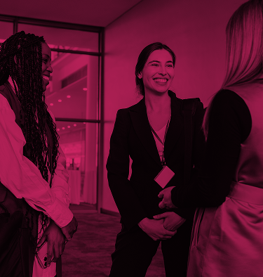 Frauen im Gespräch bei einer Veranstaltung mit pinkem Farbfilter